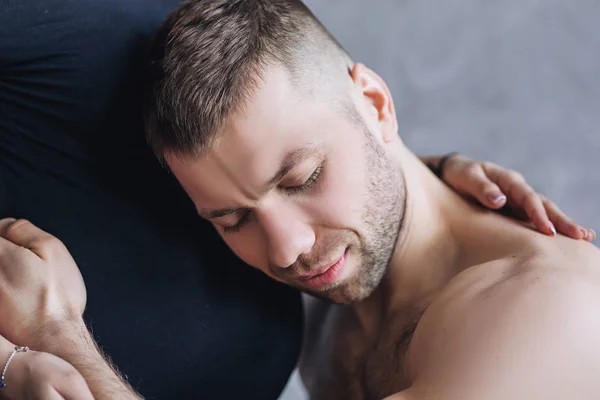 Portrait de l'homme européen dans un appartement gris, le futur père écoute son ventre de femme — Photo