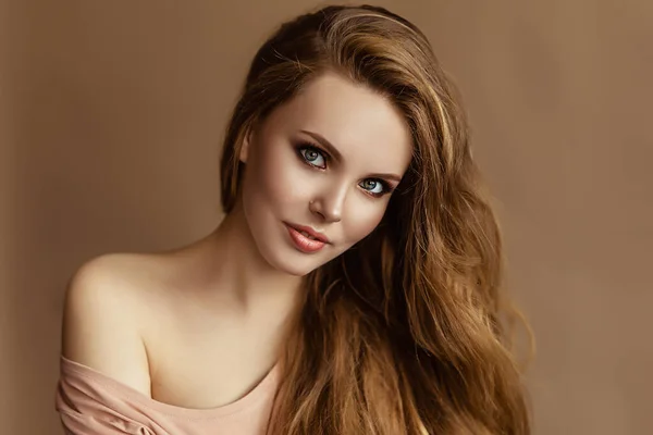 Portrait de jeune femme européenne, belle dame caucasienne aux cheveux longs et épais, joli modèle wtih yeux verts et maquillage nu, dame sur fond beige — Photo