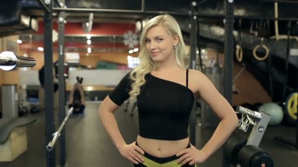 Portret piękne blond modelka, która stwarza dla nowoczesnej siłowni ogłoszenie. — Wideo stockowe