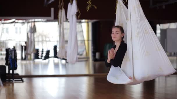 Giovane femmina sta praticando yoga aereo nel moderno club sportivo . — Video Stock