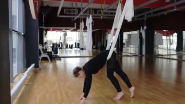 Genç Bayan lüks salonunda sinek yoga uygulamak.