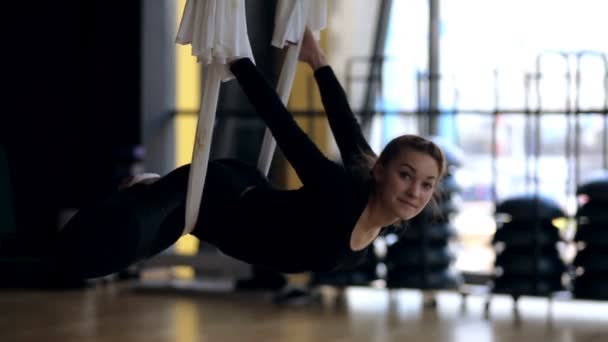 Jonge vrouw is oefenen anti lucht zwaartekracht yoga in hangmat studio. — Stockvideo