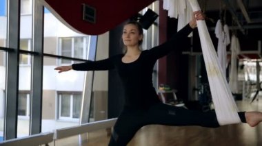 Esnek Genç kadın bacaklarını hava tuval kullanarak uzanır.