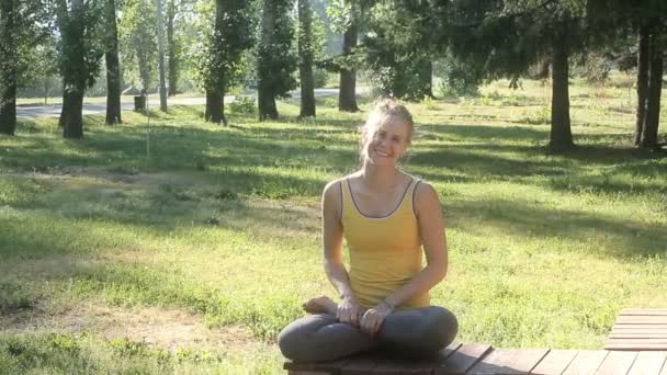 Žena sedí v lotosové pozici, cvičí jógu na čerstvém vzduchu venku — Stock video