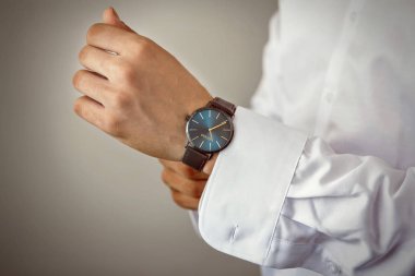 Bir beyaz gömlek, kollu gömlek kol düğmeleri ve saatler ile bir arka plan üzerinde erkek eller