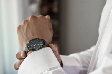 Bir beyaz gömlek, kollu gömlek kol düğmeleri ve saatler ile bir arka plan üzerinde erkek eller