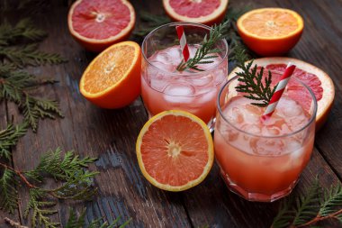 Greyfurt, buz ve meyve suyu ile taze pembe alkollü kokteyl, ahşap bir tahta üzerinde içki cam, eski rustik tarzı, seçici odak