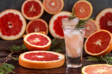 Greyfurt ve narenciye, buz ve meyve suyu, ahşap bir tahta üzerinde içki cam, eski rustik tarzı, seçici odak ile taze alkollü kokteyl