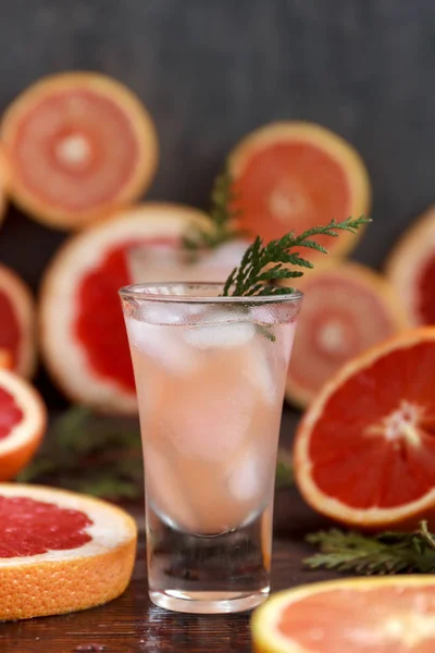Fresh alcoholic cocktail with grapefruit and citrus, ice and juice, drink glass on a wooden board, selective focus — Stock Photo, Image