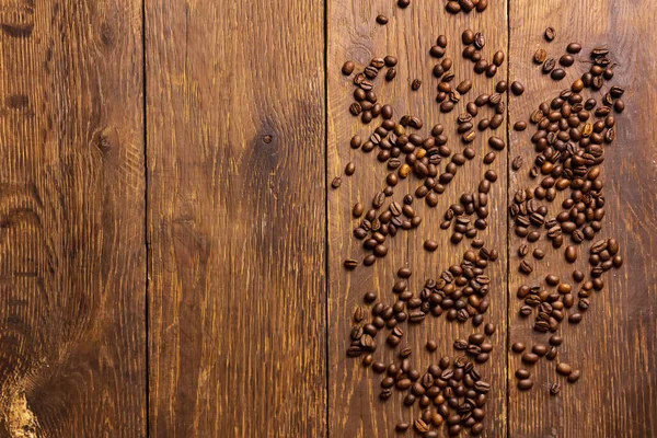 Beberapa biji kopi pada latar belakang kayu cokelat Stok Gambar