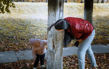 Çocuk fotoğraf çekmemek için bir ağacın arkasına saklanıyor.