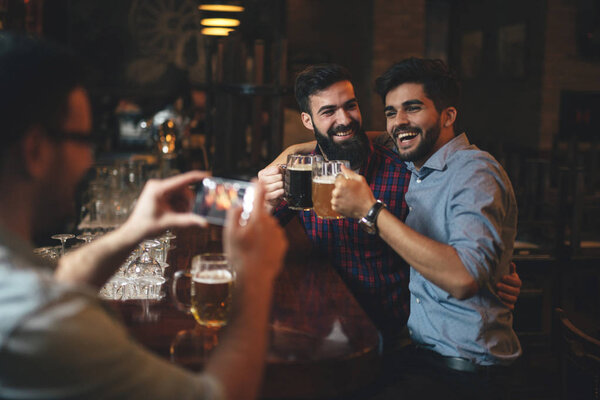 The guys in the pub are drinking beer