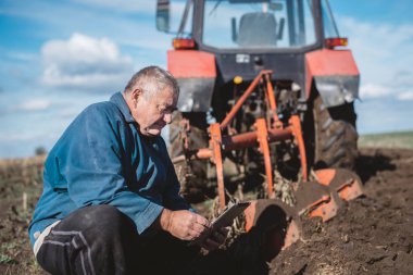 Çerçeveciye çalışma alanında onun tablet üzerinde denetler.