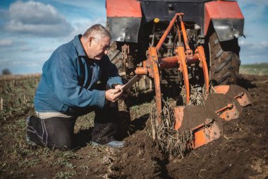 Çerçeveciye çalışma alanında onun tablet üzerinde denetler.