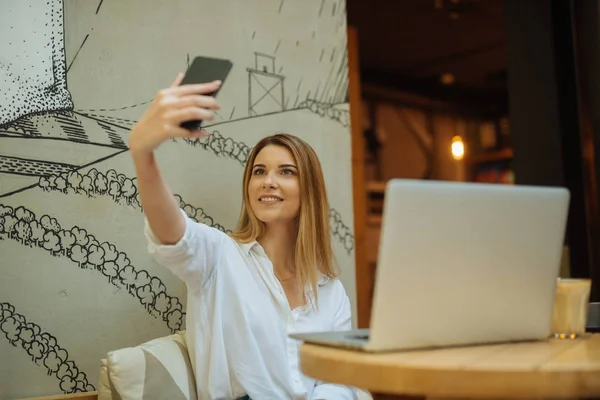 カフェ店の女の子が Selfie を撮影とノート パソコンでの作業 — ストック写真