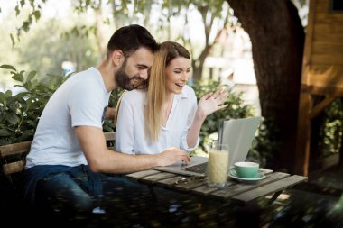 Mutlu çift kahve dükkanında laptop yanında çalışma