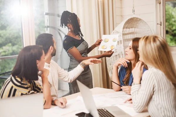 Mujer Negocios Afroamericana Mostrando Papel Con Cartas Colegas Durante Reunión — Foto de Stock