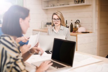 Toplantı sırasında birlikte çalışan dizüstü bilgisayarlar ile üç iş kadınları