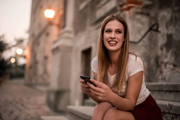 携帯電話でメッセージを入力する笑顔の素敵な女の子の肖像画 — ストック写真