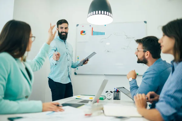 Businessman with young partners looking at whiteboard in creative office