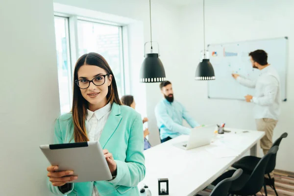 Retrato Mujer Negocios Usando Tableta Mientras Sus Colegas Comunican Juntos — Foto de Stock