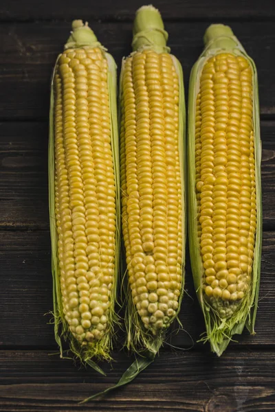 Corn on a dark wood background — Stock Photo, Image