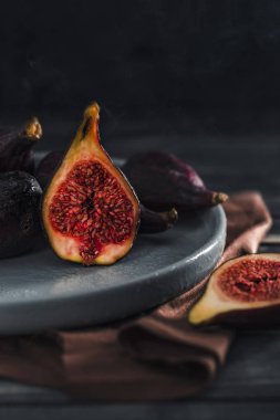 Ahşap arka planda bir plakaya kesilmiş taze incir