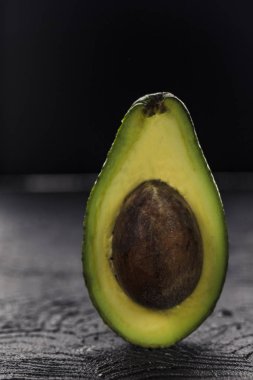 Copysp ile karanlık arka plan closeup üzerinde kemik ile avokado kesim