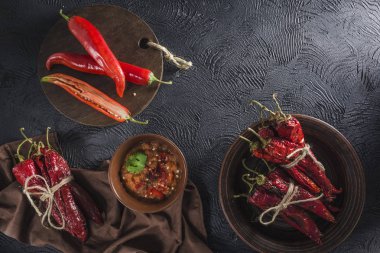 Seramik tabaklarda koyu bir arka plan üzerinde baharatlı biber, flatlay.