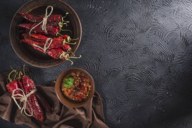 Seramik tabaklarda koyu bir arka plan üzerinde baharatlı biber, flatlay.