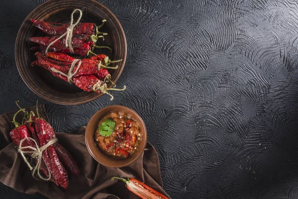 Seramik tabaklarda koyu bir arka plan üzerinde baharatlı biber, flatlay.