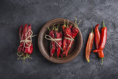 Seramik tabaklarda koyu bir arka plan üzerinde baharatlı biber, flatlay.