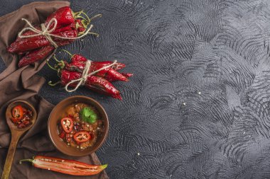 Seramik tabaklarda koyu bir arka plan üzerinde baharatlı biber, flatlay.