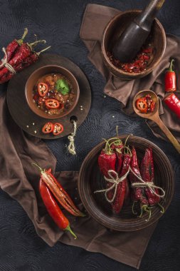 Seramik tabaklarda koyu bir arka plan üzerinde baharatlı biber, flatlay.