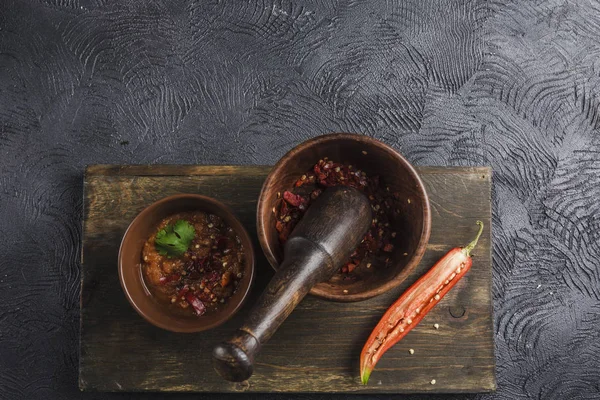 Ahşap bir B üzerinde seramik plakalar üzerinde koyu bir arka plan üzerinde Baharatlı biber