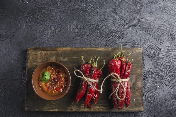 Ahşap bir B üzerinde seramik plakalar üzerinde koyu bir arka plan üzerinde Baharatlı biber