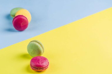 Mavi ve sarı arka plan üzerinde çok renkli makaronlar, üst görünüm