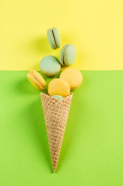 Yeşil ve sarı ba bir waffle koni içinde çok renkli macaroons