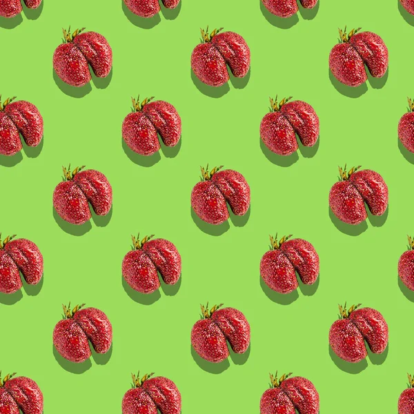 Eamless pattern of ugly strawberries on a green background — Stock Photo, Image