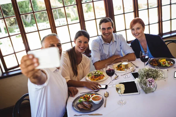 商务人士在餐厅用手机自拍 — 图库照片