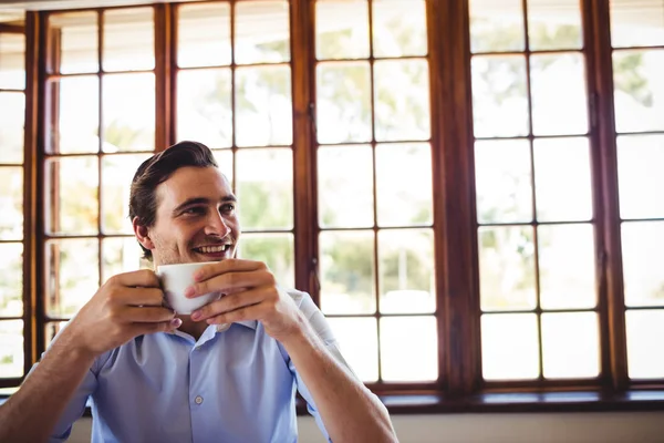 笑みを浮かべて男がレストランでコーヒーを飲んで — ストック写真