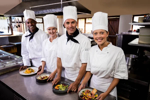 Gruppe Von Köchen Hält Teller Mit Zubereiteten Speisen Der Küche — Stockfoto