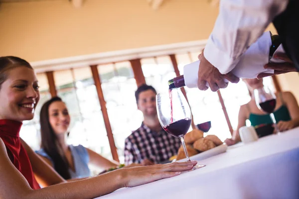 餐厅服务员在桌上的酒杯里倒红酒 — 图库照片