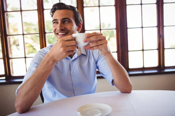 笑みを浮かべて男がレストランでコーヒーを飲んで — ストック写真
