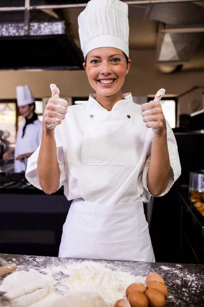 女厨师在酒店的厨房里竖起大拇指 — 图库照片