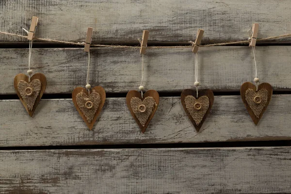Καρδιά Σχήμα Διακοσμήσεις Κρέμεται Από Νήμα Εναντίον Ξύλινη Σανίδα — Φωτογραφία Αρχείου