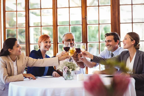 レストランでワインを乾杯幸せなビジネスの人々 をメガネします — ストック写真