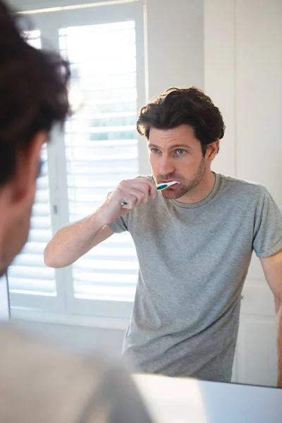 Uomo Guardando Specchio Lavandosi Denti Bagno Casa — Foto Stock