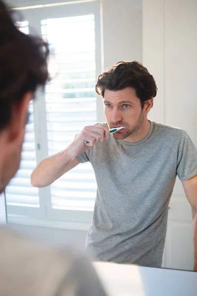 Man Van Spiegel Kijken Zijn Tandenpoetsen Badkamer Thuis — Stockfoto