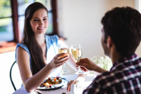 年轻夫妇在餐厅敬酒白葡萄酒杯 — 图库照片